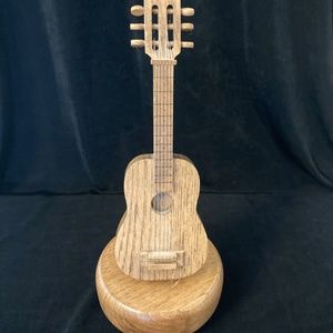 Guitar wooden vintage music box with strings and six tuning pegs.